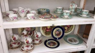 2 shelves of tea sets & plates including Cottage Rose (66 pieces)