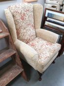 A fabric covered wing back armchair