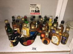 A quantity of whisky & spirit miniatures with glasses