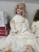 A porcelain headed doll marked 1902/6, 63cm,/25",