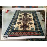 A blue, green and cream patterned rug, approximately 64.