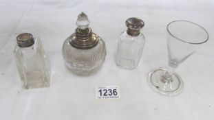 3 silver topped glass bottles and a cordial glass