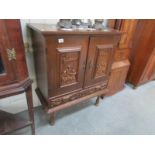 A continental carved oak 2 door cupboard