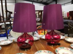 A pair of burgundy globe table lamps with shades