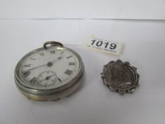 A pocket watch and a Victorian coin brooch