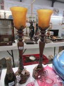 A pair of bronze colour table lamps with amber glass shades