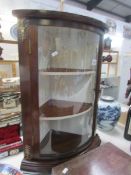 A mahogany dome front corner cabinet