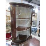 A mahogany dome front corner cabinet