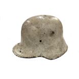 A German military helmet (possibly M1916/M1917 type) with winter camouflage white paint (no liner)