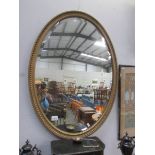 An oval gilt framed bevel edged mirror