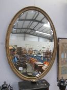 An oval gilt framed bevel edged mirror