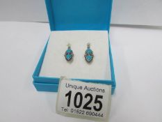 A pair of silver and turquoise ear pendants