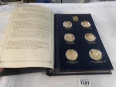 A presentation album of 24 gold plated silver Churchill centenary medallions produced by the