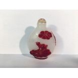 a circa 19th/20th century red overlay carved glass snuff bottle depicting 2 carp swimming under a