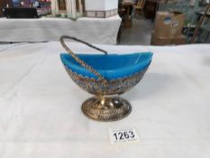 A silver sweet meat basket with blue glass liner,