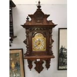 An oak wall clock with brass dial