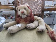 A vintage soft toy reclining lion (stitching on underside loose)