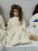 A porcelain headed doll marked Made in Germany 390, 58cm/22",