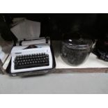 An Erika portable typewriter and an enamel stew pan