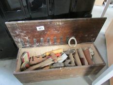 A lidded wooden box of tools