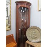 A corner cabinet with concave glass