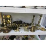 A shelf of brass ware including horse brasses,