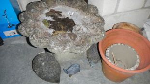 A bird bath and a quantity of plant pots