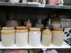 A shelf of stoneware and glass bottles etc