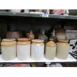 A shelf of stoneware and glass bottles etc