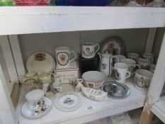 A shelf of commemorative china etc