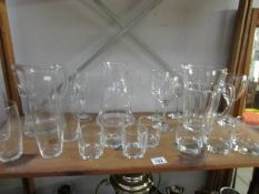 A shelf of glassware including 3 water jugs,