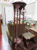 A mahogany pot stand on barley twist supports