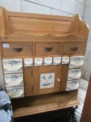 A pine spice rack with ceramic drawers