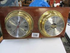 A ships clock and barometer on wooden back