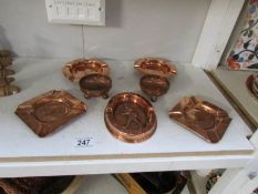 A quantity of copper ashtrays