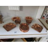 A quantity of copper ashtrays