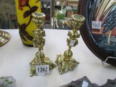 A pair of brass Lincoln Imp candlesticks