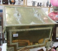 A brass coal box with lion head handles