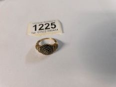 A yellow metal ring set black stones,