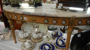 An oval gilded coffee table with marble top