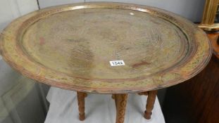 An Islamic brass topped table