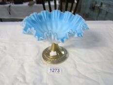 A fluted blue glass bowl on metal stand