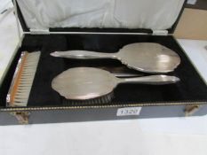 A cased silver backed brush set,