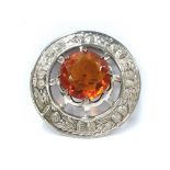 A large white metal Celtic brooch set large amber coloured stone