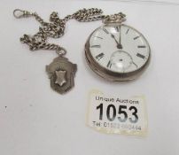 A silver pocket watch on chain with silver fob