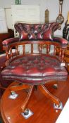 A mahogany and leather revolving captain's chair