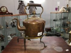 A copper kettle on a brass trivet