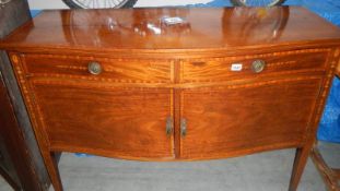 A mahogany inlaid serpentine front sideboard