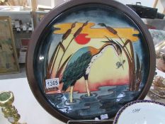 A large Moorcroft charger decorated with heron and in a wooden frame