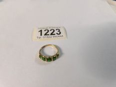 A 9ct gold ring set green stones,